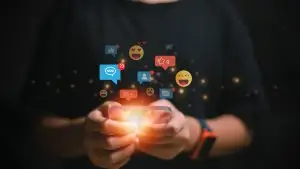 Person mit Smartphone und Emojis